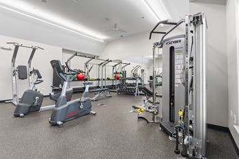 A gym with a variety of equipment including treadmills, stationary bikes, and weight machines.